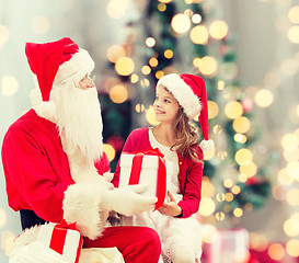 Image showing smiling little girl with santa claus and gifts