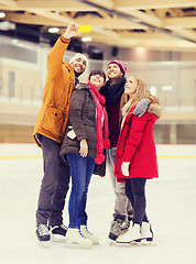 Image showing happy friends taking selfie on skating rink