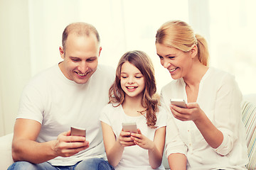 Image showing parents and little girl with smartphones at home