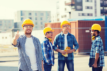 Image showing group of smiling builders in hardhats outdoors