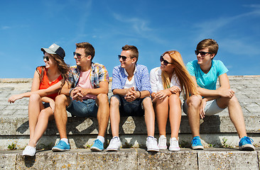 Image showing group of smiling friends sitting on city street