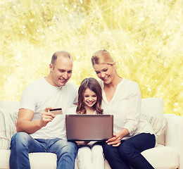 Image showing happy family with laptop computer and credit card