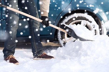 Image showing closeup of man digging snow with shovel near car