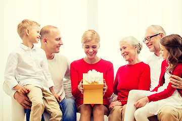 Image showing smiling family with gift at home