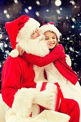 Image showing smiling little girl with santa claus and gifts