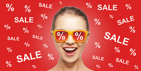 Image showing happy teenage girl in shades with sale signs