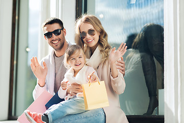 Image showing happy family with child and shopping bags in city