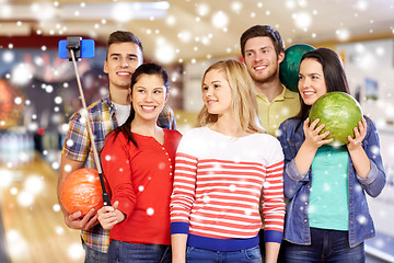 Image showing happy friends taking selfie in bowling club