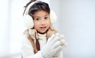 Image showing happy little girl wearing earmuffs
