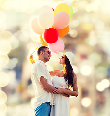 Image showing smiling couple with air balloons outdoors