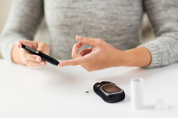 Image showing close up of woman making blood test by glucometer