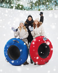 Image showing group of smiling friends with snow tubes