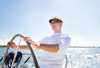 Image showing senior man at helm on boat or yacht sailing in sea