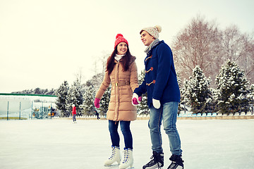 Image showing happy couple ice skating on rink outdoors