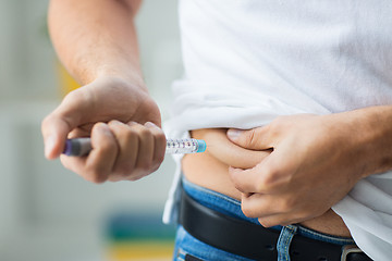 Image showing man with syringe making insulin injection