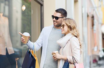 Image showing happy couple with shopping bags and coffee in city