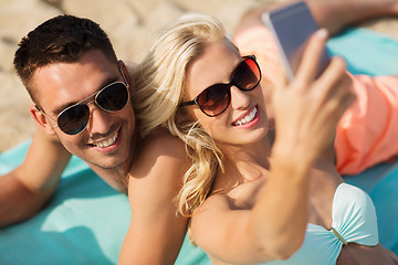 Image showing happy couple in swimwear walking on summer beach