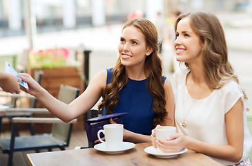 Image showing women paying money to waiter for coffee at cafe