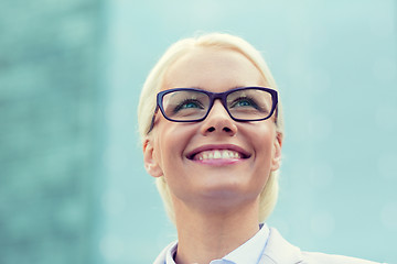 Image showing young smiling businesswoman over office building