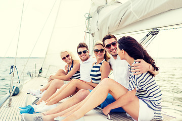 Image showing smiling friends sitting on yacht deck