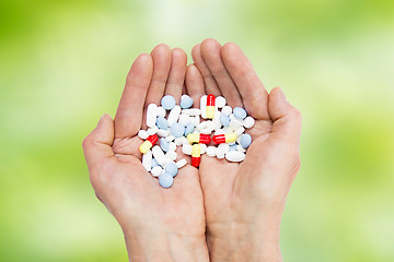 Image showing close up of senior woman hands with pills