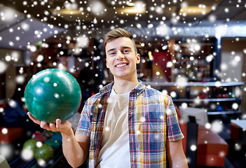 Image showing happy young man holding ball in bowling club