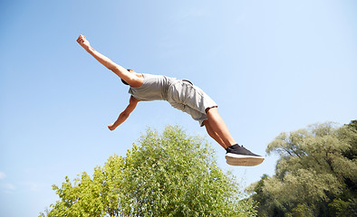 Image showing sporty young man jumping in summer park