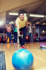 Image showing happy young man throwing ball in bowling club