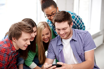 Image showing group of happy students with smartphone at school