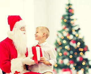 Image showing smiling little boy with santa claus and gifts