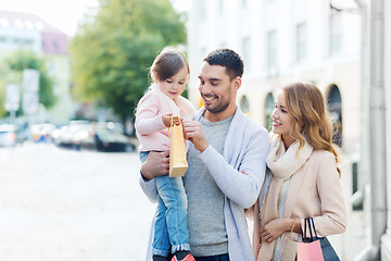 Image showing happy family with child and shopping bags in city