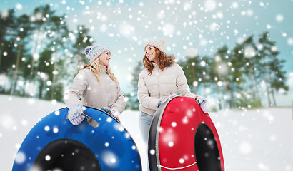 Image showing happy girl friends with snow tubes outdoors