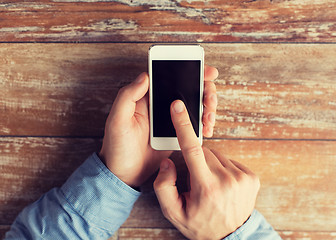 Image showing close up of male hands with smartphone on table