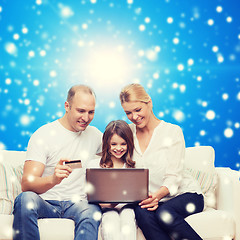 Image showing happy family with laptop computer and credit card