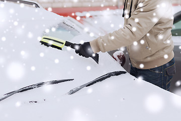 Image showing closeup of man cleaning snow from car