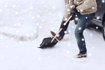 Image showing closeup of man digging snow with shovel near car