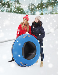 Image showing happy girl friends with snow tubes outdoors