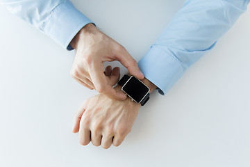 Image showing close up of male hands setting smart watch