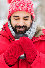 Image showing happy man with thermos cup in winter forest