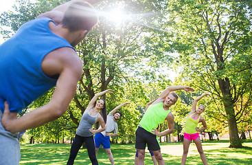 Image showing group of friends or sportsmen exercising outdoors