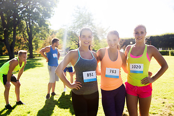 Image showing happy young sporty women with racing badge numbers