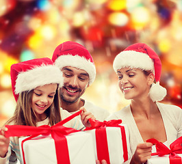 Image showing happy family in santa helper hats with gift boxes