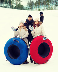 Image showing group of smiling friends with snow tubes