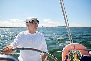 Image showing senior man at helm on boat or yacht sailing in sea