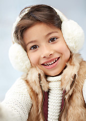 Image showing happy little girl wearing earmuffs