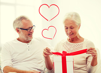 Image showing happy senior couple with gift box at home