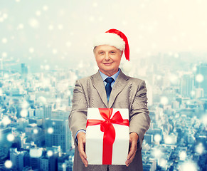 Image showing smiling man in suit and santa helper hat with gift