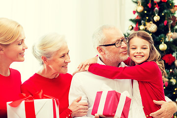 Image showing smiling family with gifts at home