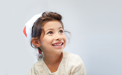 Image showing happy little girl in santa hat over gray