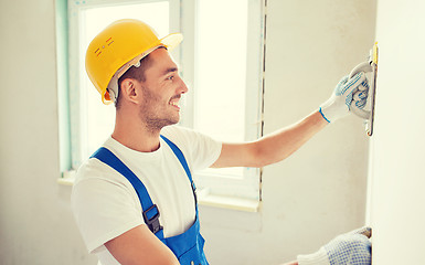 Image showing smiling builder with grinding tool indoors